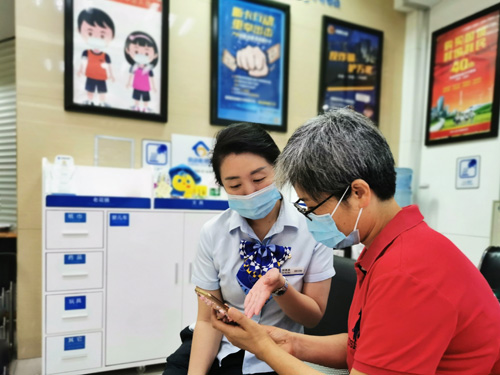 建行成都第六支行，大堂經(jīng)理為客戶介紹手機(jī)銀行&ldquo;大字&rdquo;模式